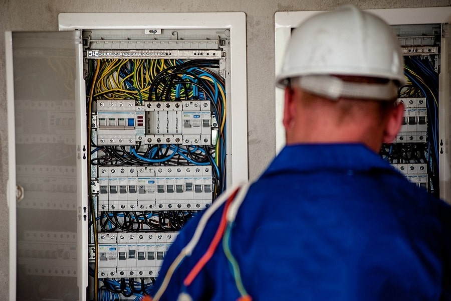 Best Electrical Contractor in Greenacres an Electrician Standing in Front of a Fuse Box