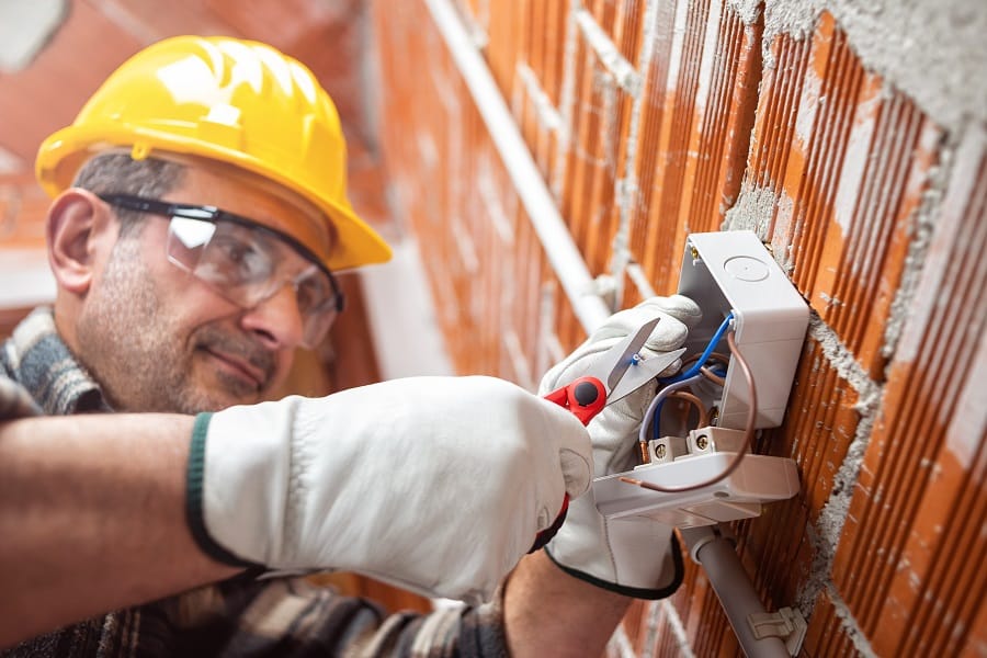 Electrician at work in an electrical system of a construction si