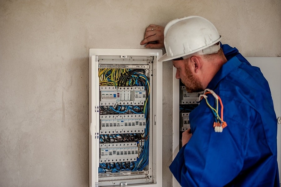 Best Electrical Contractor in Lake Worth Florida Electrician Looking at a Fuse Box on a Wall