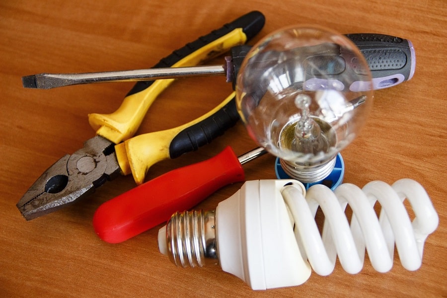 Best Electrical Contractor in Lake Worth Florida Electrician Tools on a Wooden Table Next to Light Bulbs