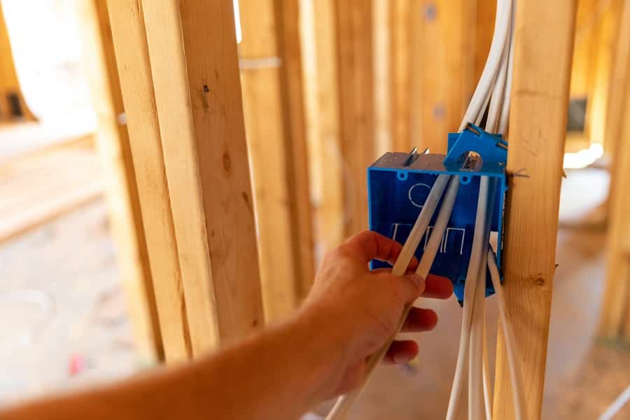 Best Electrician in Hobe Sound Hand working on electrical wires in new home construction