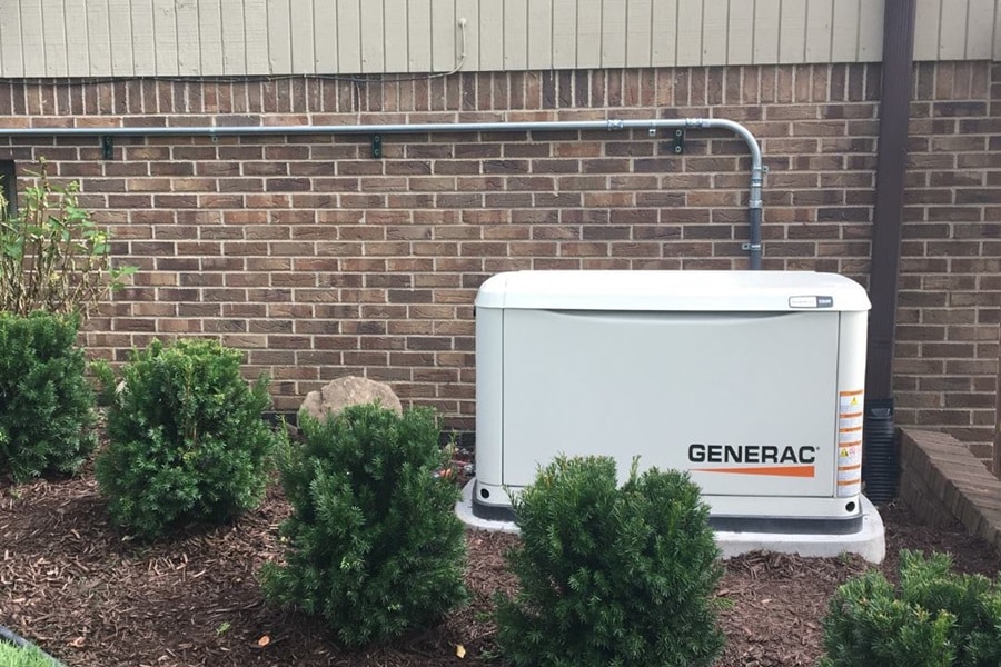 Certified Generac Service Provider in Palm Beach County Florida a Generac Standby Generator Outside of a Home with Some Bushes in Front of it