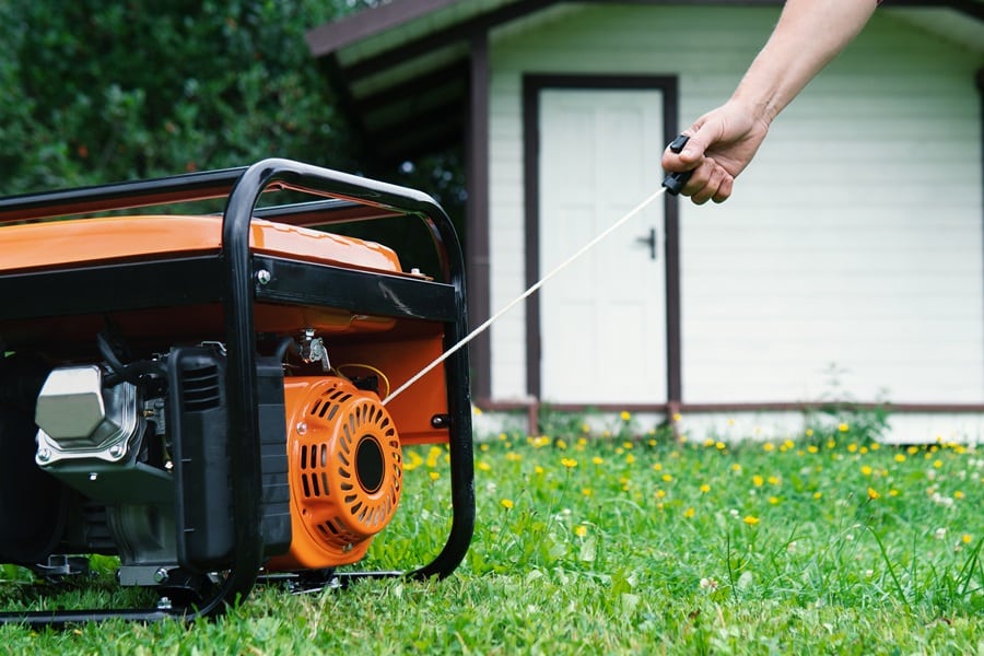 Why Should I Buy a Generator View of Someone Turning on a Portable Generator in Their Yard