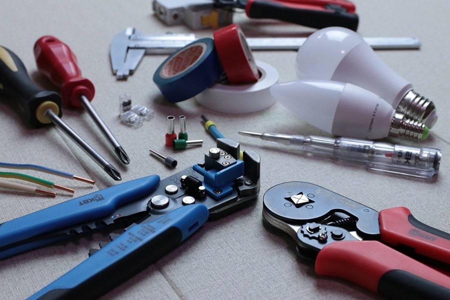 Best Electrician in Jensen Beach Florida Close Up of Electrician Tools Including Pliers, Wire Cutters, Screw Drivers, Magnets, and Light Bulbs