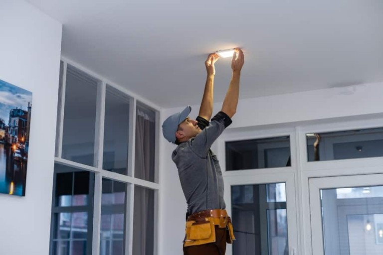 Best Palm Beach Shores Electrician An electrician is installing spotlights on the ceiling