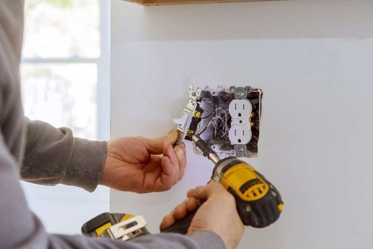 Best Electrician in North Palm Beach Close Up of an Electricians Hands Installing an Outlet