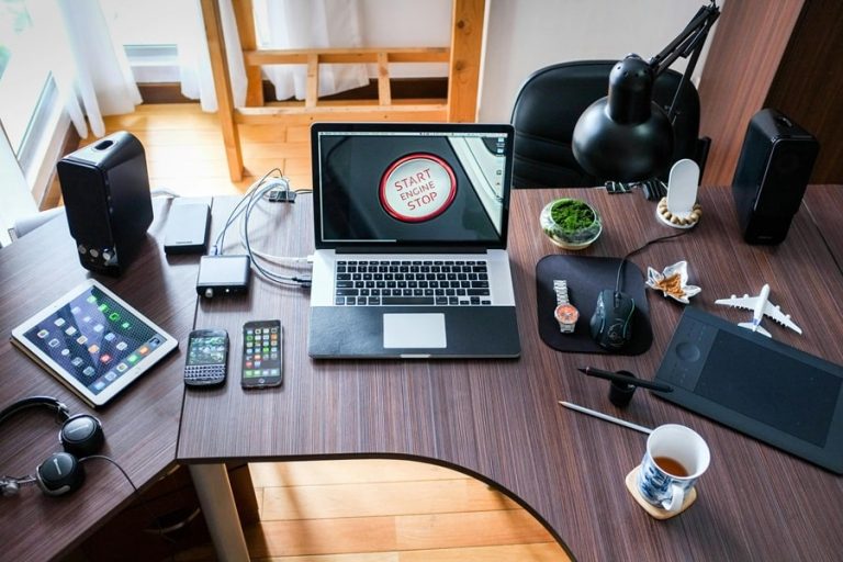 Best Electrician Near Me North Palm Beach Florida a Desk Covered with Electronics Including Laptops, Cell Phones, Chargers, and More