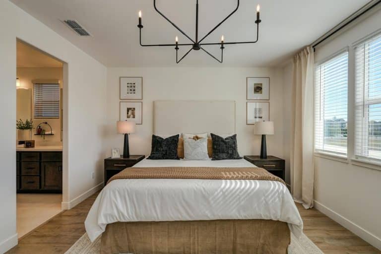 Best Chandelier Installation Electrician in Delray Beach View of a Bed in a Bedroom with a Chandelier Hanging Above