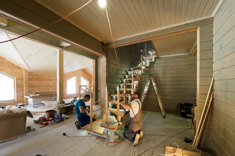 Best Home Remodel Electrician in Delray Beach Two Men Working on a Staircase in a Home with Exposed Beams