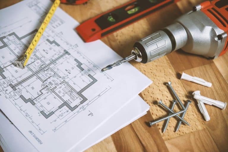 Best Home Remodel Electrician in Wellington Florida a Drill, Leveler, Pencil, Nails, and Blueprints on a Wooden Surface