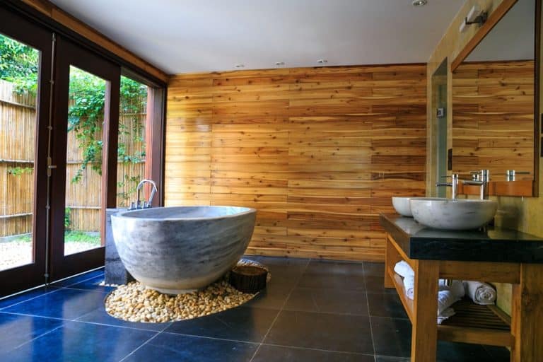 Best Bathroom Remodel Electrician in Stuart Florida a Bamboo Bathroom with a Tub in the Center on a Bed of Rocks