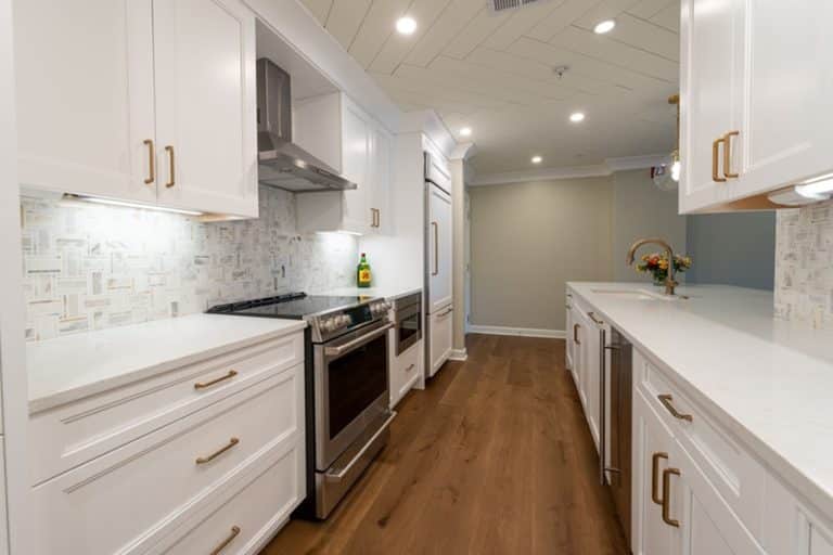 Best Kitchen Remodel Electrician in Stuart Florida a Kitchen with White Cabinets, Gold Handles, and White Countertops