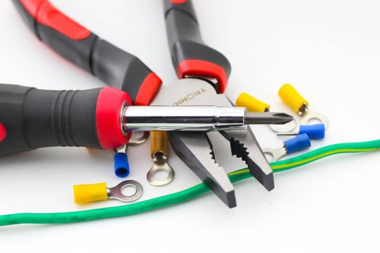 Best Electrical Contractor in Loxahatchee Groves Wire Conduit with Pliers and a Screw Driver on a White Surface